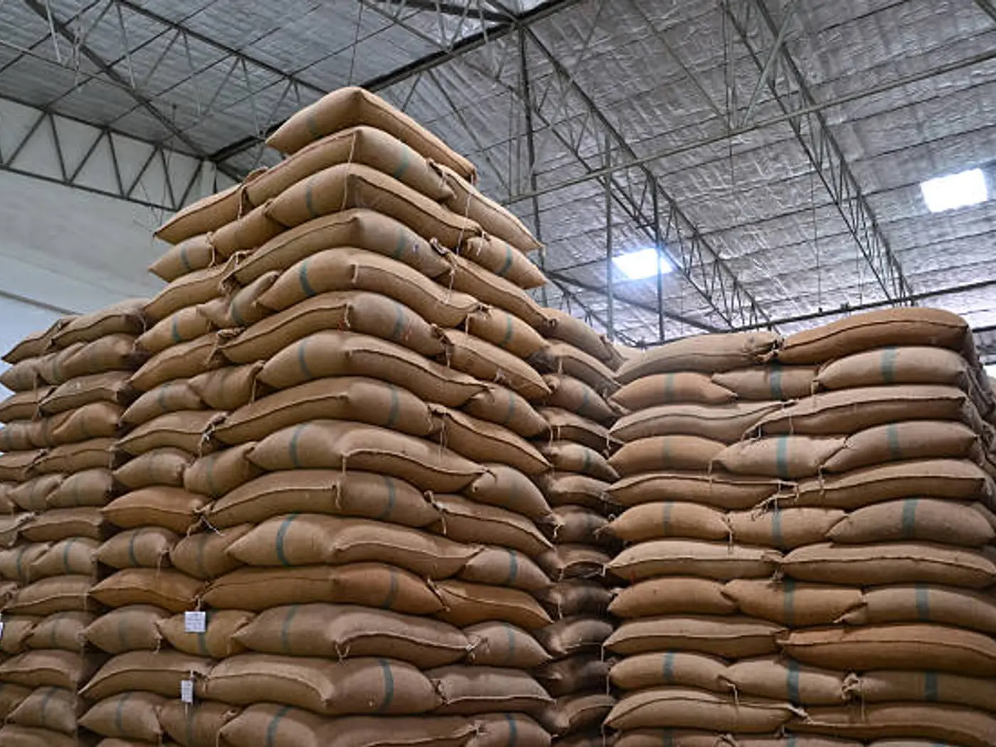 Tall stacks of grain sacks inside a warehouse